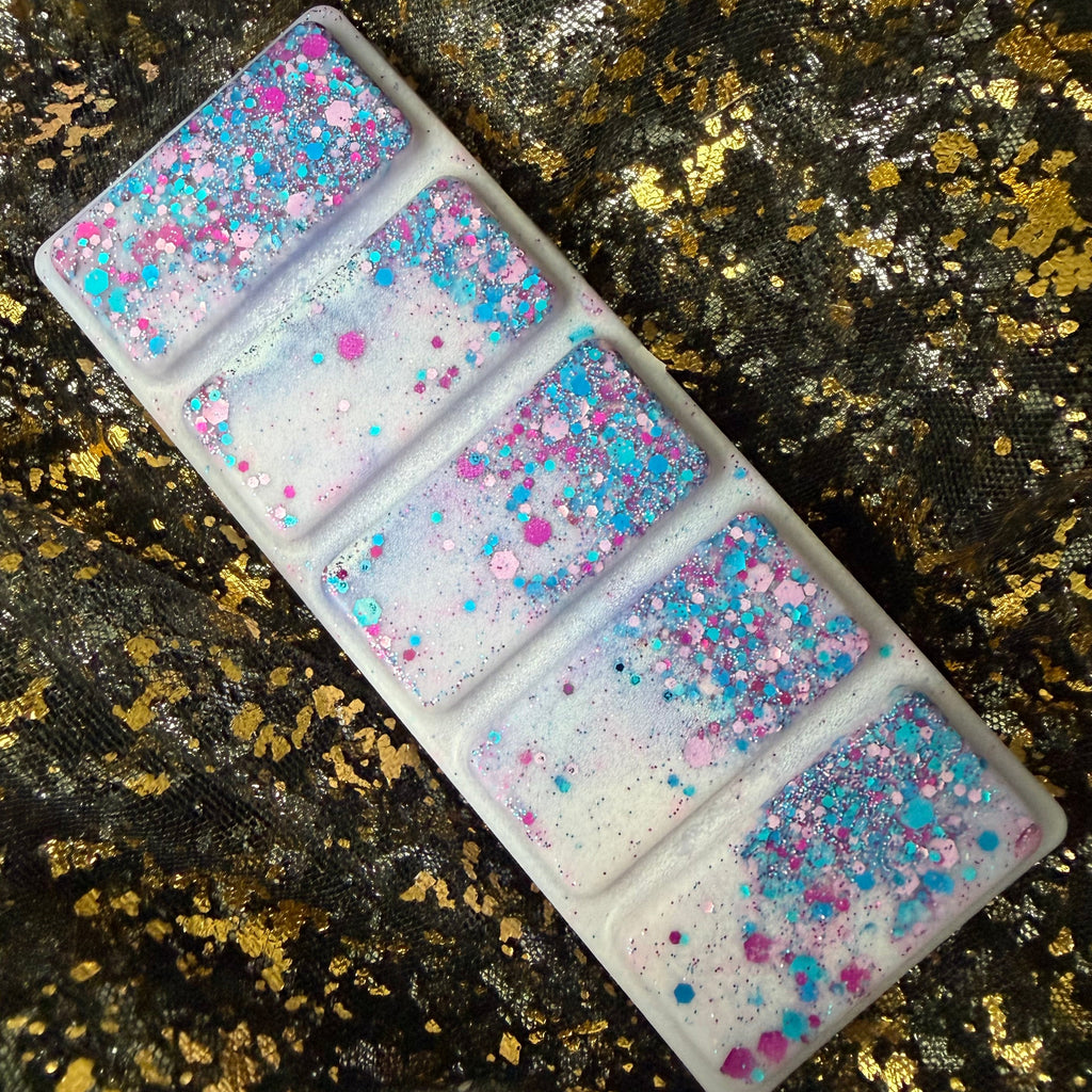 older version of the light purple coloured blackberry and bay leaf scented soy wax melt displaying the purple, pink and blue glitter. 