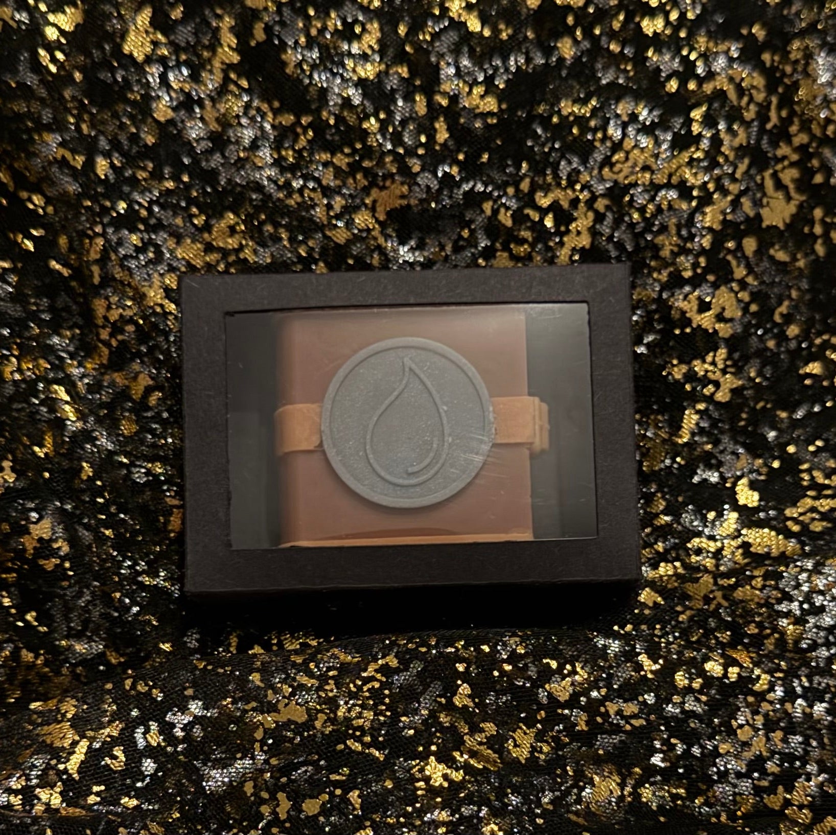 Zodiac Academy Water Element House Aqua wax melt in black gift box with droplet embossed spell book design on gold glitter background