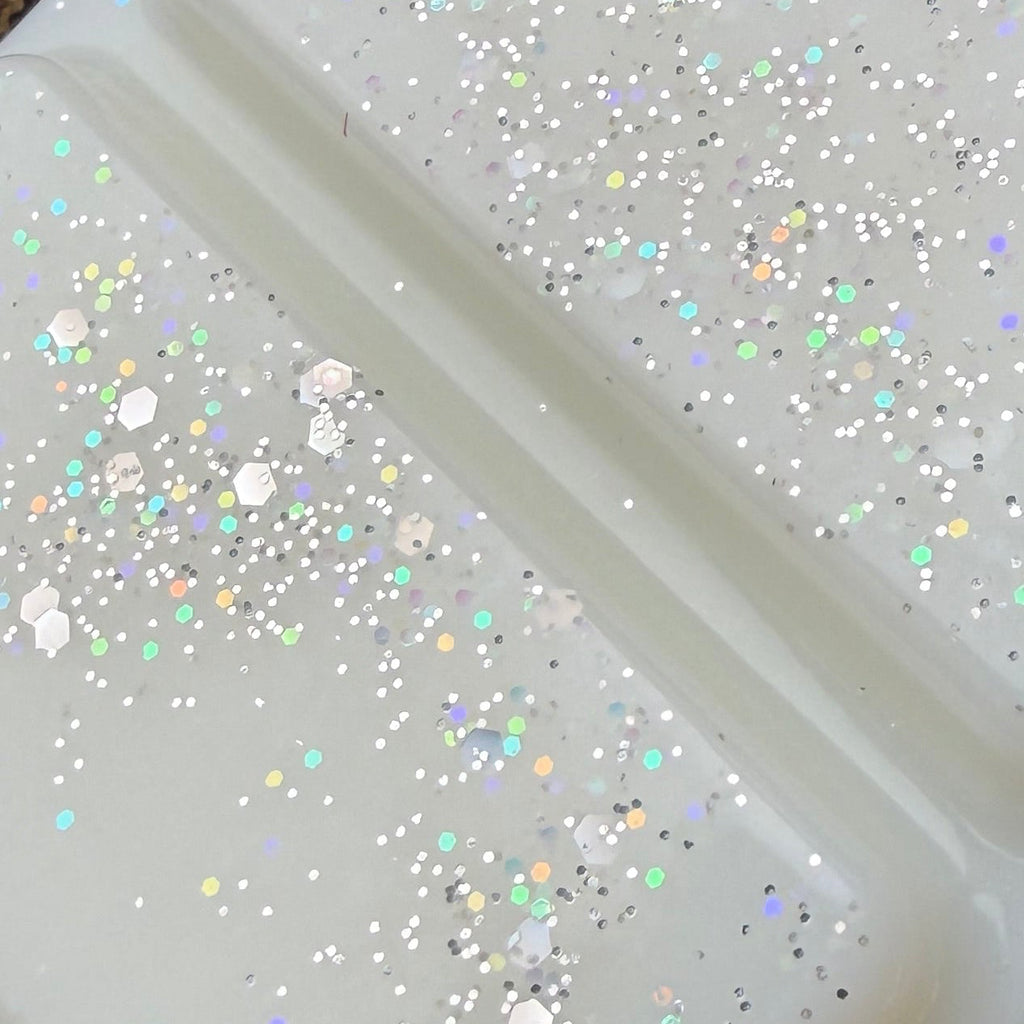 Zoomed-in photograph of The Boyfriend Hoodie wax melt showing fine silver shimmer and holographic glitter reflecting pink, green and blue.