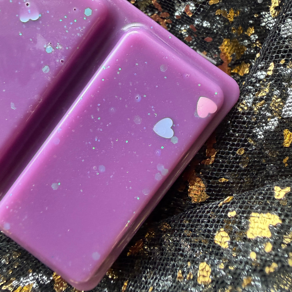 Close-up of two Midnight Wish segments showing the colour transition from lilac to bright pink and scattered heart-shaped glitter.