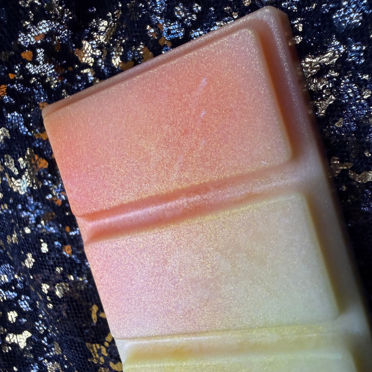 Close-up of the upper Honeybee wax melt segments, showing the transition from warm orange to pale honey yellow with a soft pearlescent shimmer.