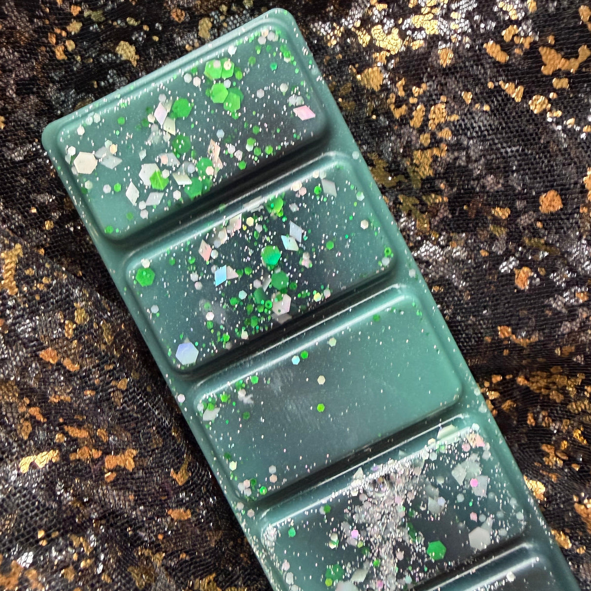 Close-up of The Darkness Commander character-inspired wax melt showing the decorative details across the five individual segments.