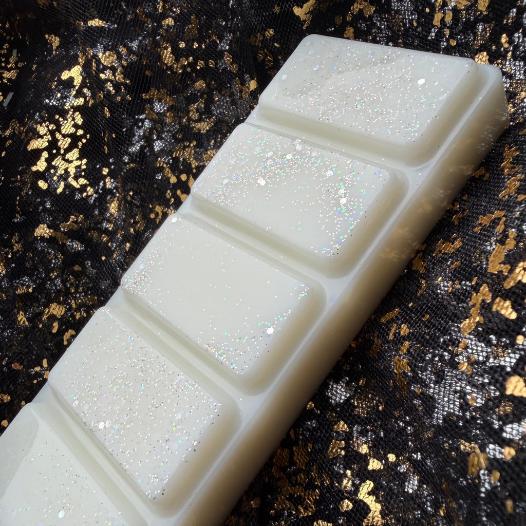 Side-angled photograph of The Boyfriend Hoodie five-segment wax melt showing its creamy white colouring and lightly scattered glitter.