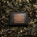 Zodiac Academy Fire Element House Ignus wax melt in black gift box with flame embossed spell book design on gold glitter background