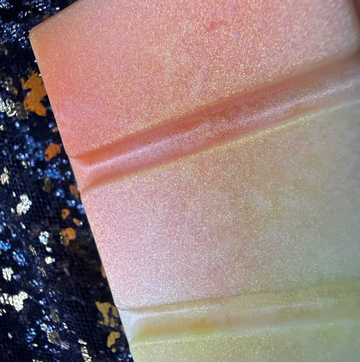 Detailed close-up of the Honeybee soy wax melt showing blended orange, peach and honey-yellow colours across two raised rectangular segments.