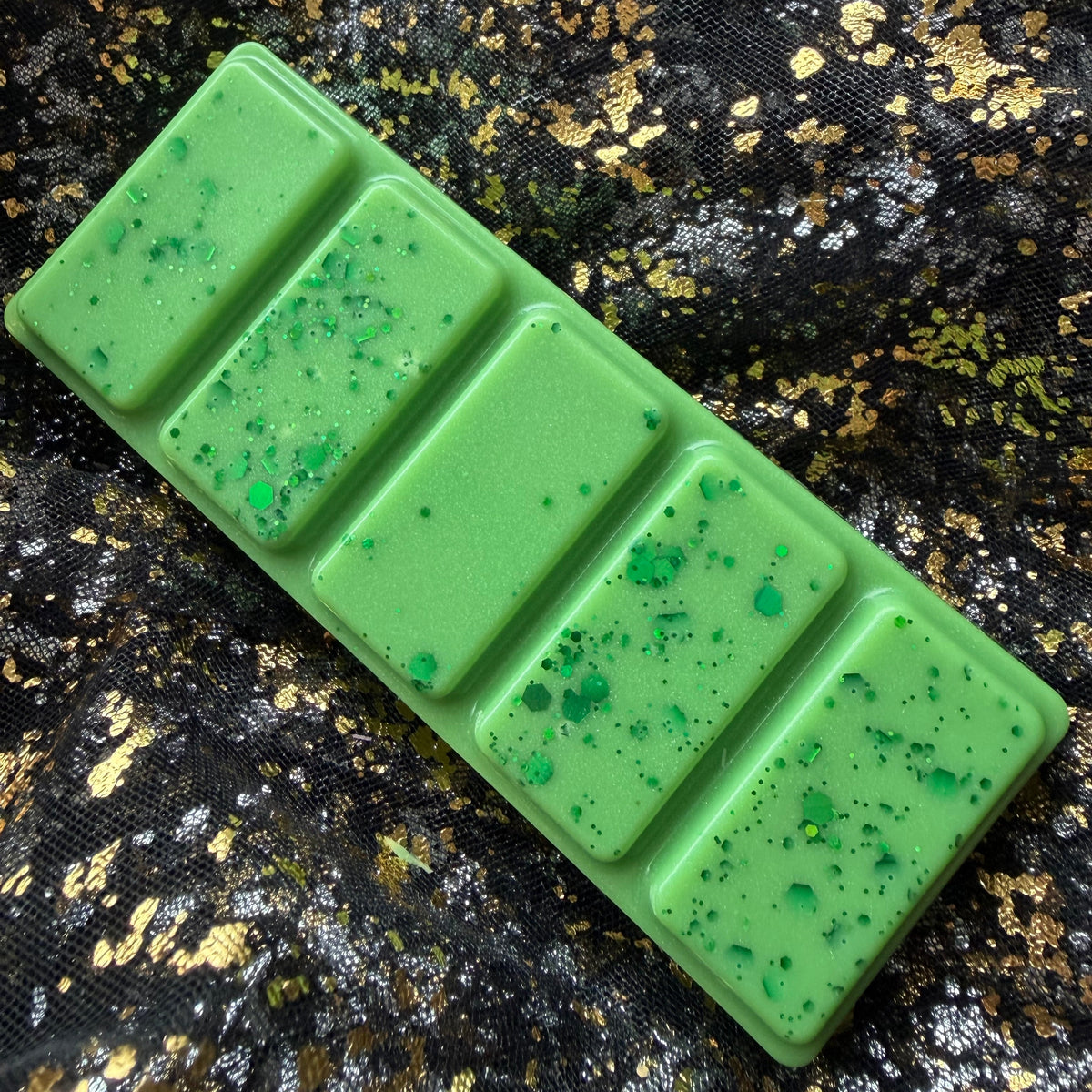 Mirror Mirror book-inspired high-quality soy wax melt removed from its clamshell and positioned at an angle, with a strong tart Granny Smith apple fragrance.