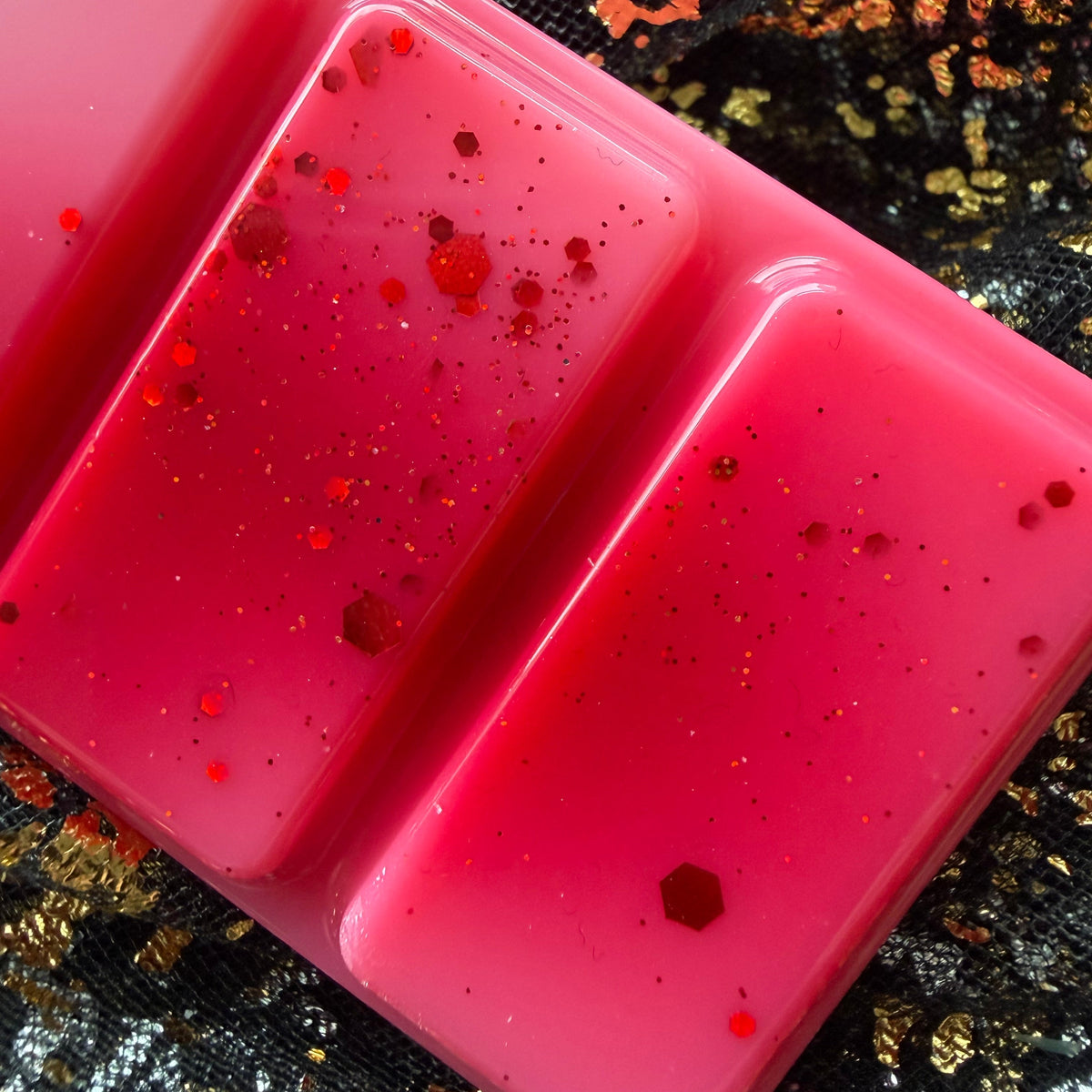 Close up of glittered segments, Fated Mates bookish wax melt in red white and pink, hand-poured in Yorkshire for fantasy romance readers.