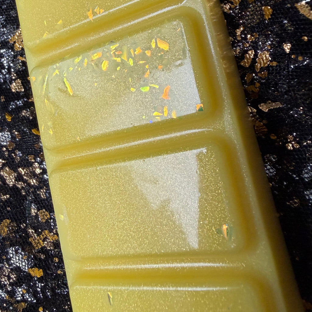Angled close-up of the yellow Sherbet Lemon scented wax melt showing its shiny glossy finish.