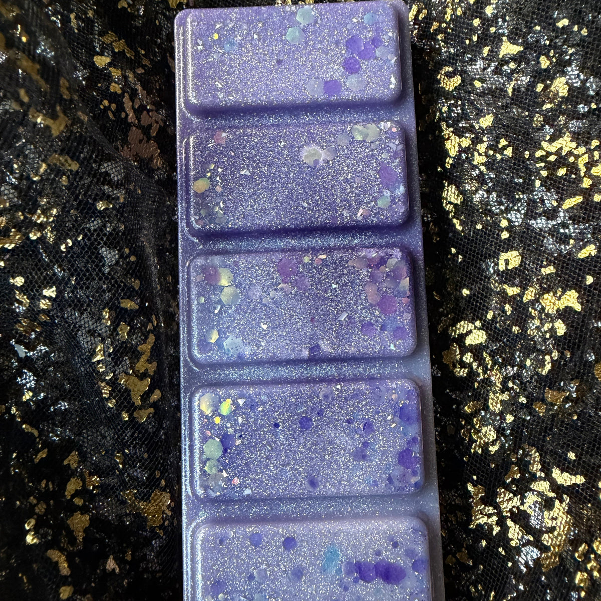 The Femme Fatale FMC-inspired high-quality soy wax melt removed from its clamshell and positioned at an angle, with citrus, jasmine, rose, amber and vanilla.