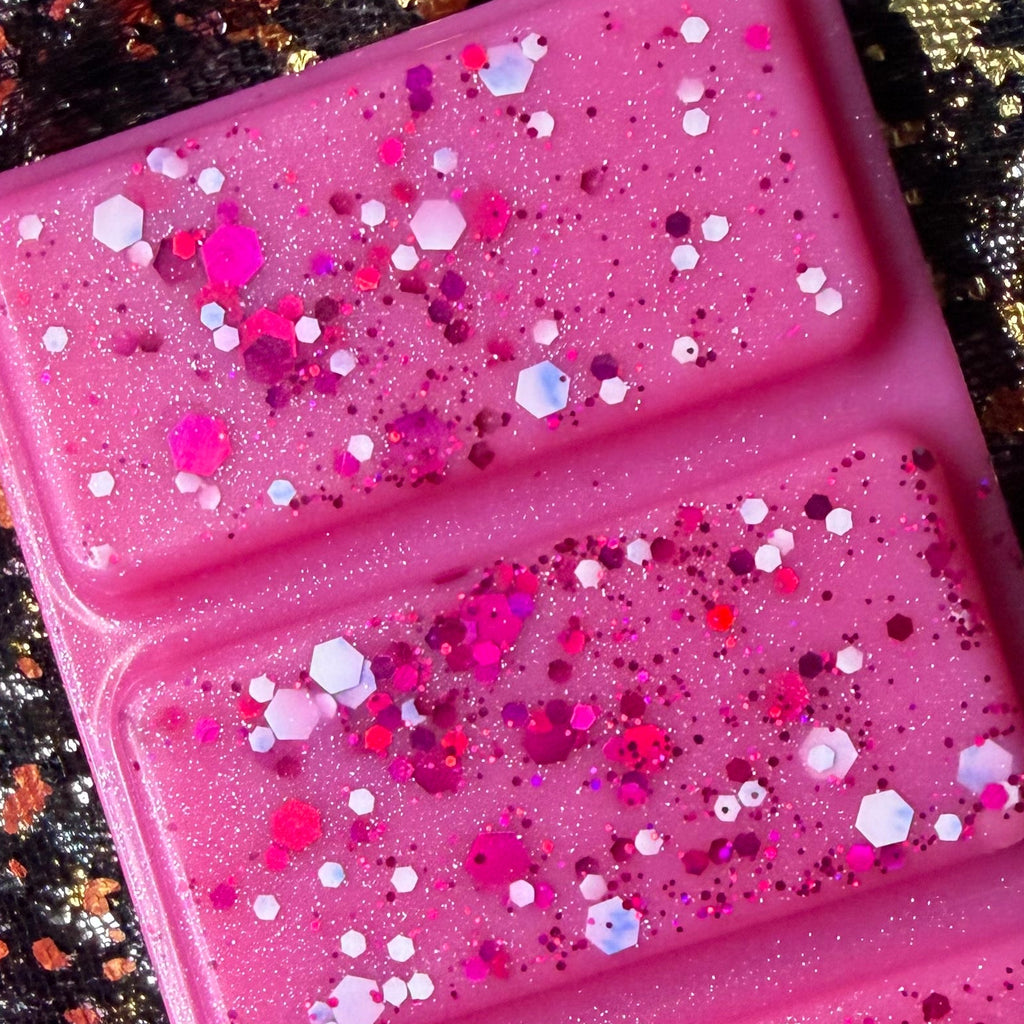 Zoomed-in view of the Winter Fairy Tale wax melt showing the bright pink soy wax melt, showing sparkling glitter and decorative finish.